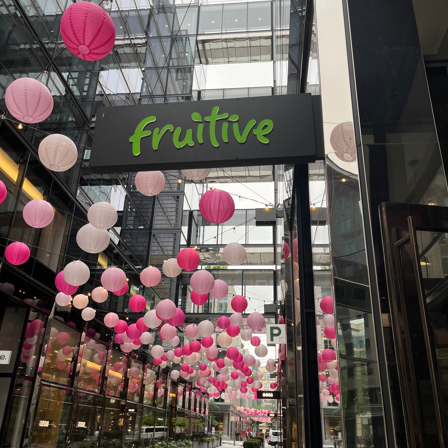 Fruitive store with pink and white balloons in a modern building setting
